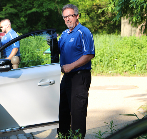 A male valet attendant getting in a car to park it