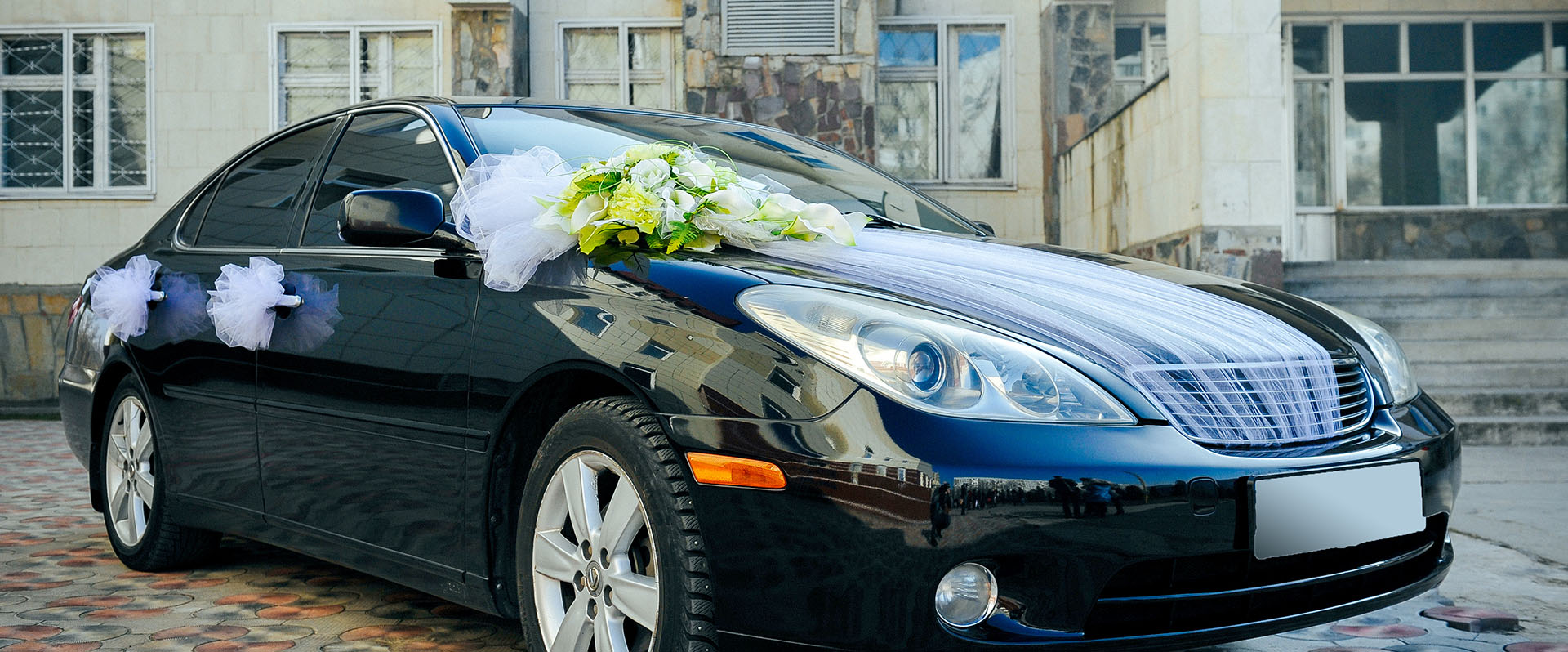 car decorated with wedding flowers and ribbons